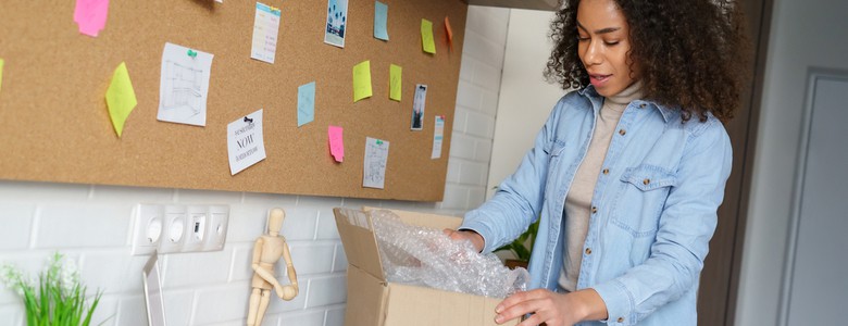 A female student unpacking her things onto a dorm room desk