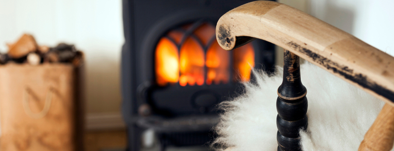 A rocking chair pulled up close to a cosy fire
