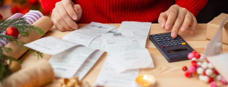 A woman looking at receipts on a table at Christmas