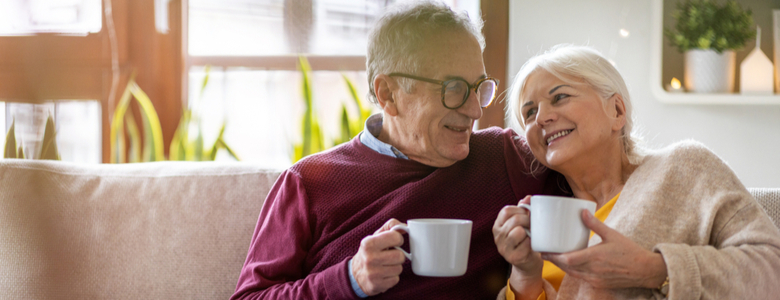 An older couple sat happily on a sofa