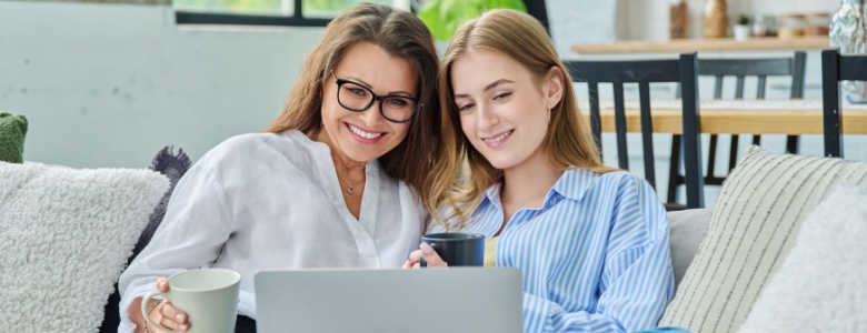 A woman using her laptop with her daughter.